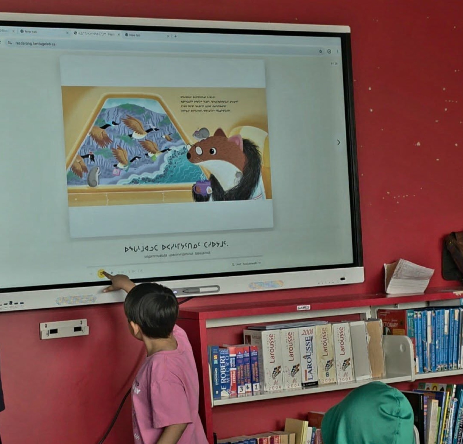 A student reading a Read-Along book on a classroom screen