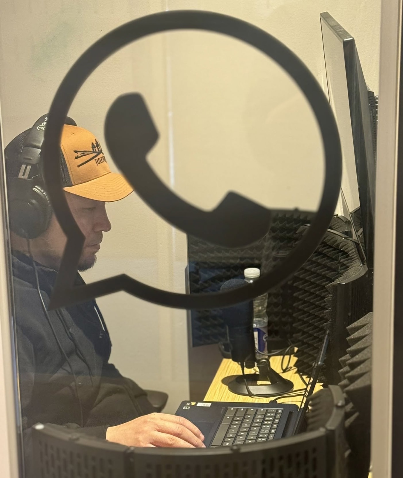 A voice actor recording in a booth